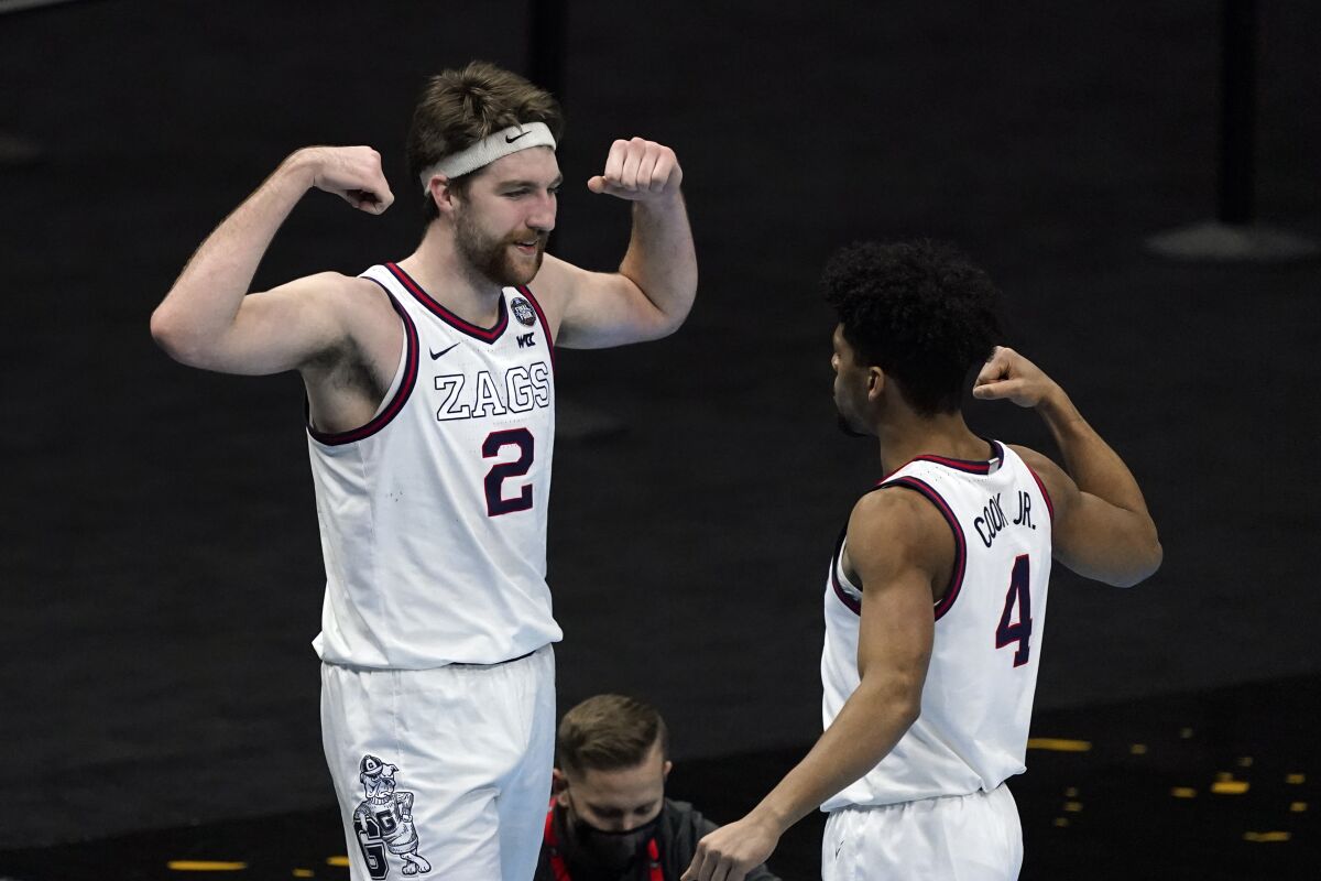 FILE - Gonzaga forward Drew Timme (2) celebrates with teammate guard Aaron Cook (4) after making a basket during the second half of a men's Final Four NCAA college basketball tournament semifinal game against UCLA at Lucas Oil Stadium in Indianapolis, in this Saturday, April 3, 2021, file photo. The Zags were the runaway top choice in The Associated Press Top 25 men’s college basketball preseason poll released Monday, Oct. 18, 2021. Gonzaga lost AP All-Americans Corey Kispert and Jalen Suggs to the NBA, but second-team selection Drew Timme (19.0 points, 7.0 rebounds) and starting guard Andrew Nembhard return. (AP Photo/Darron Cummings, File)