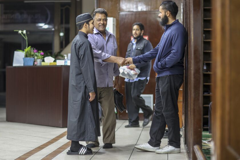 LOS ANGELES, CA, WEDNESDAY, MARCH 4, 2020 - Maminul Haque greets Munem Uddin as Abdul Rauf Islam, left, looks on at the Islamic Center of Southern California. The ICSC has issued precautionary measures for its congregants in regards to the coronavirus. They've asked that the Alhamdulillah, a formal, but friendly greeting that includes a handshake, a hug, and a kiss on the cheek be avoided. The center believes it "may be worth avoiding touching" and that a hand on the heart, a respectful nod, and a warm smile are preferred. The center is asking sick members of faith to stay home and avoid Friday's traditional Jumma prayer. They are also asking that sick children at the center's New Horizon School system and Sunday School be kept home. (Robert Gauthier/Los Angeles Times)