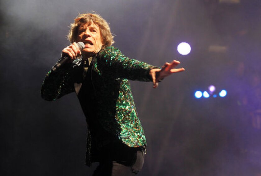 FILE - Mick Jagger of The Rolling Stones performs in Glastonbury, England on June 29, 2013. Jagger's jacket is among 55 L'Wren Scott creations going on sale this week at Christie’s in London. (Photo by Jim Ross/Invision/AP, File)