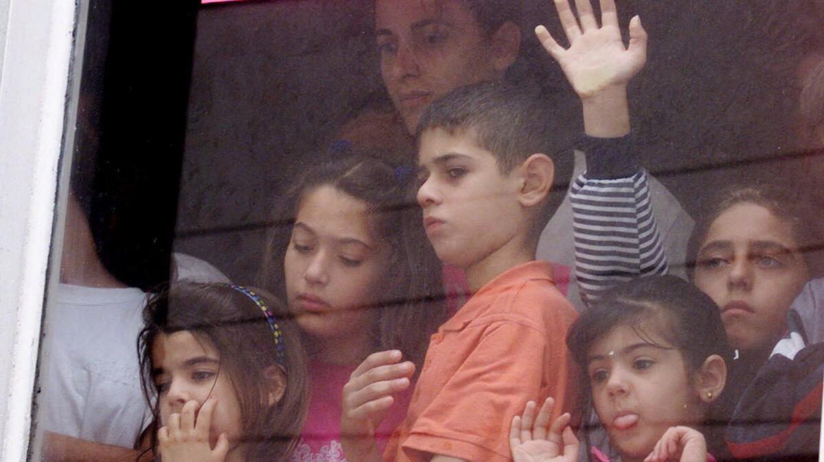 Iraqi children look from a window in a hotel in Tijuana, Mexico,as they wait to apply for asylum in the United States in Sept. of 2000.