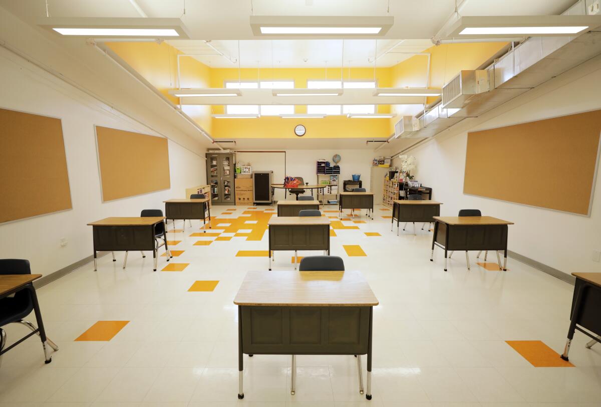 An empty classroom with desks spaced far apart