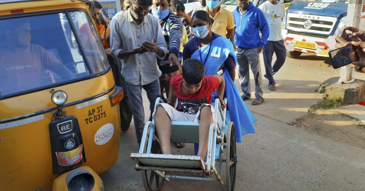 A boy is brought in a wheelchair to a hospital in Eluru, in southern India.