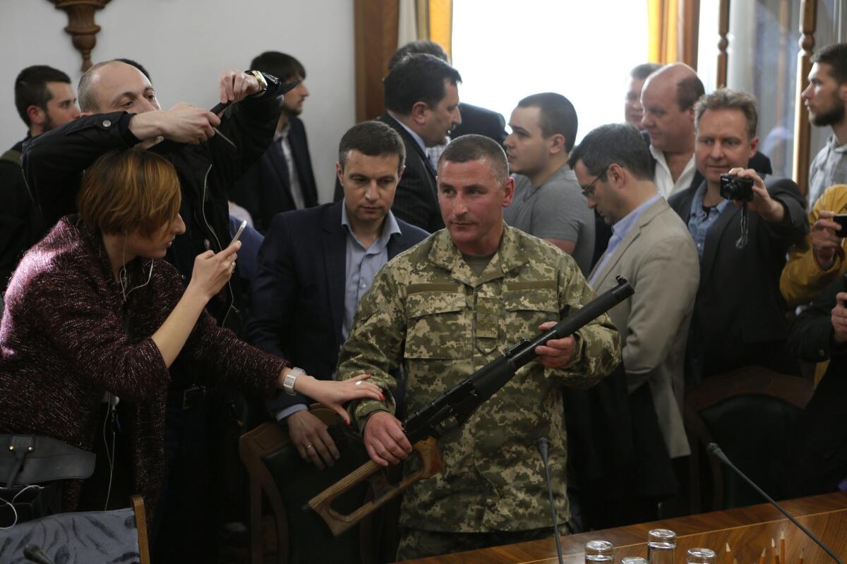 Ukrainian brigade commander Viktor Nikolyuk at a news conference May 18 in Kiev displays a rifle seized from two captured Russian soldiers.