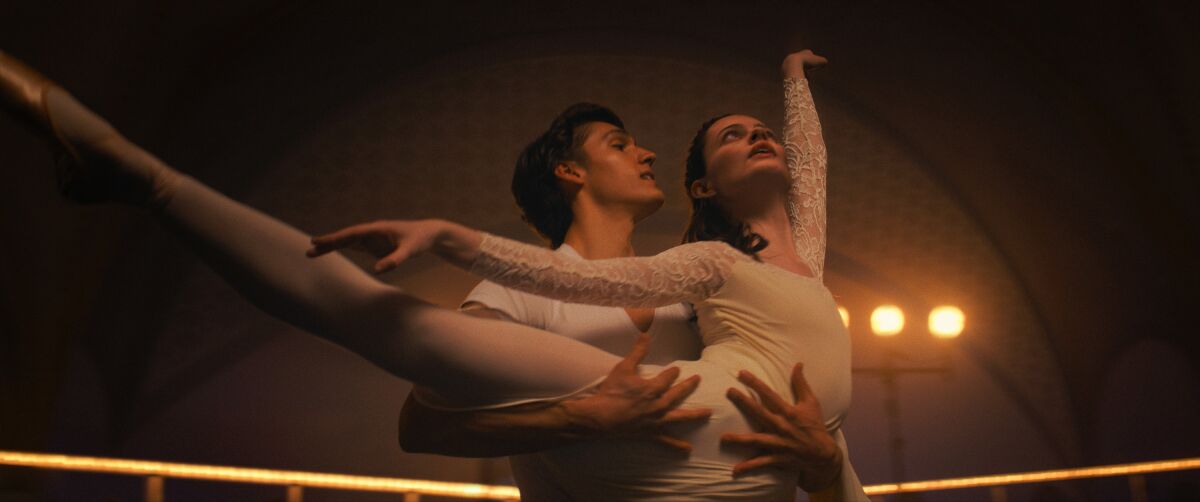 Two dancers in white perform as partners