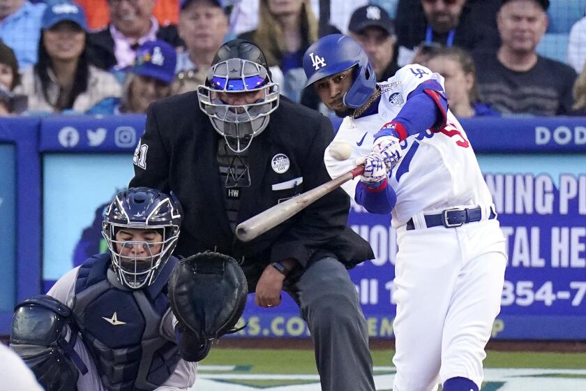 Dodgers' Mookie Betts hits a home run as New York Yankees catcher Jose Trevino looks on in a game on June 2, 2023.