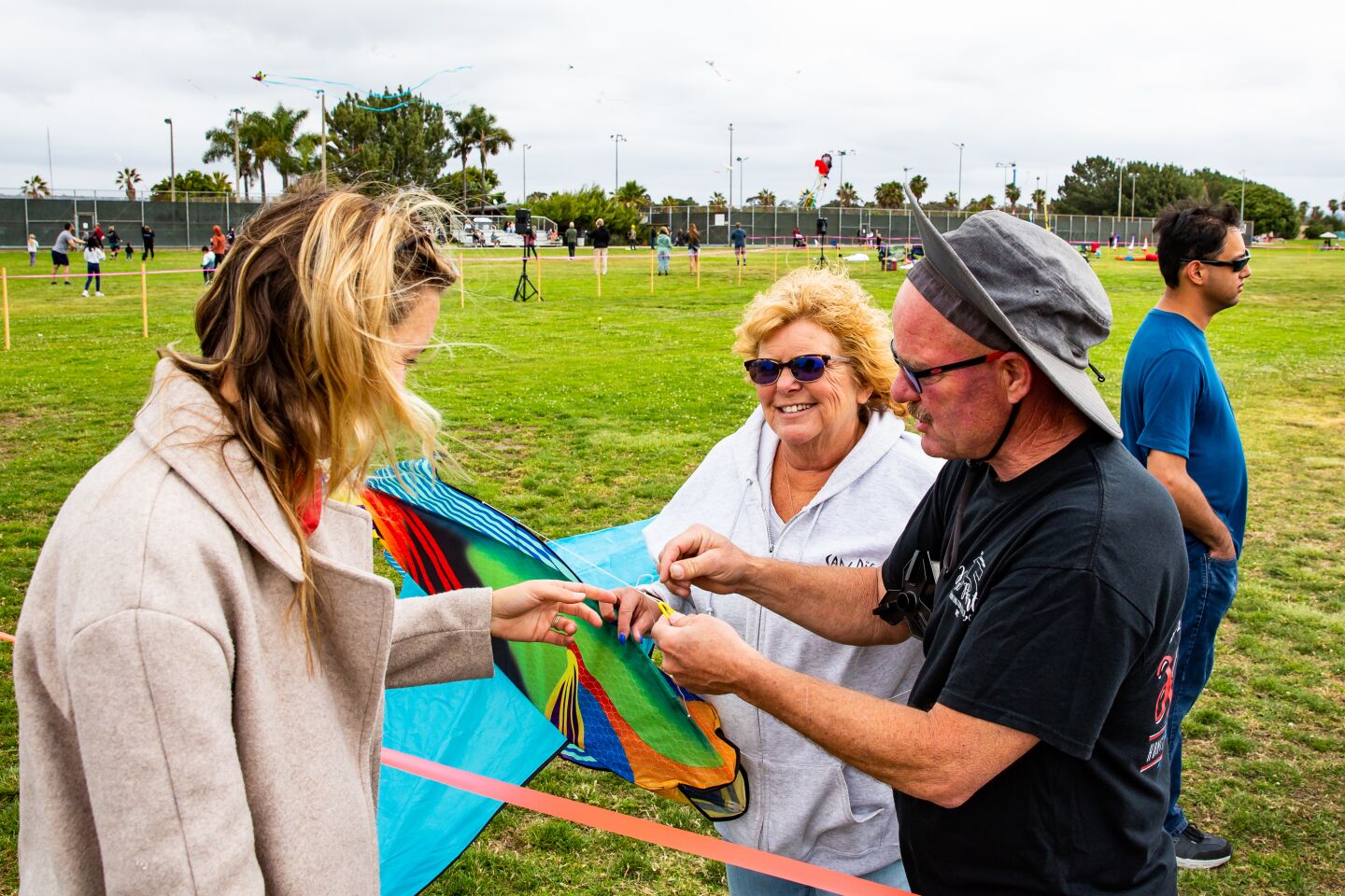 Jenni Rodden (left) gets some help with her fish kite from Laura and Russell Dickison.