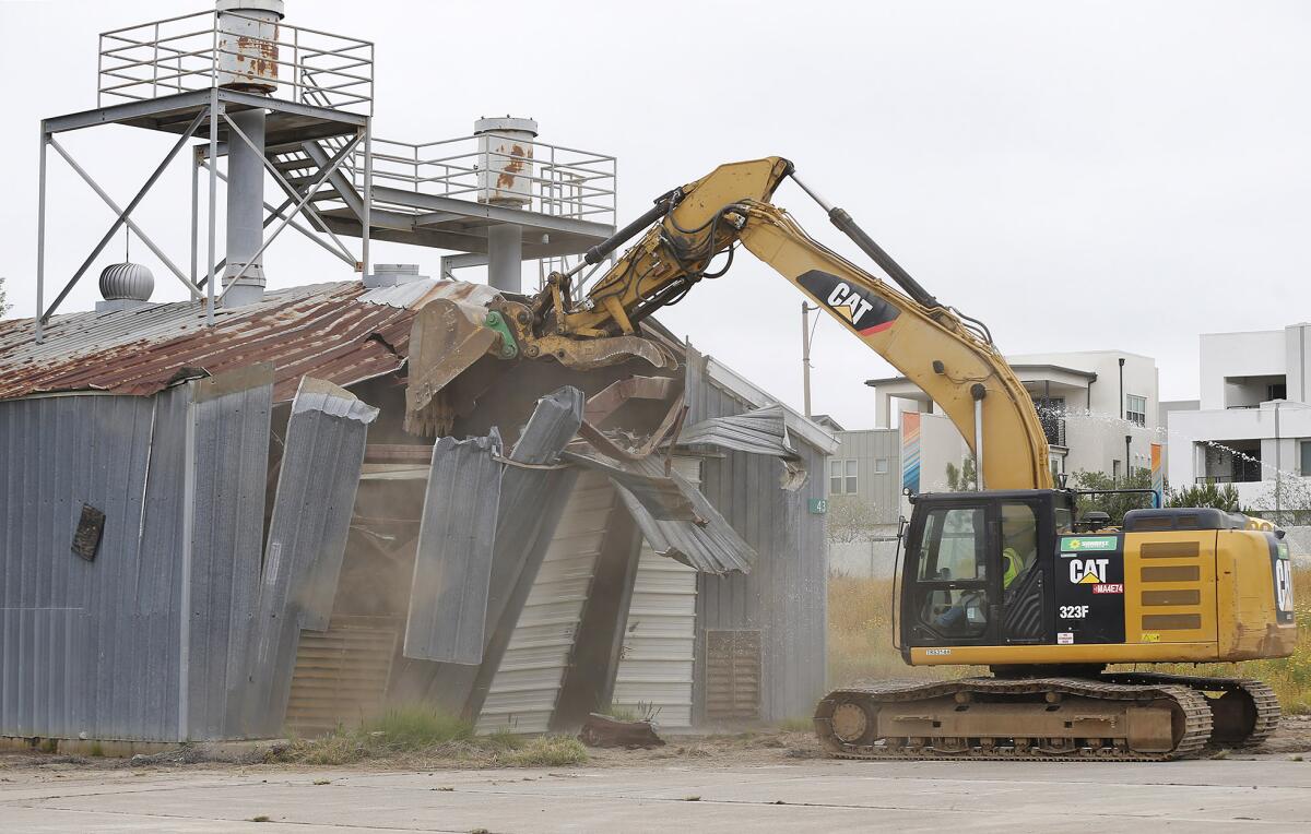 An excavator demolishes an old military structure during a groundbreaking ceremony for the Great Park in Irvine.