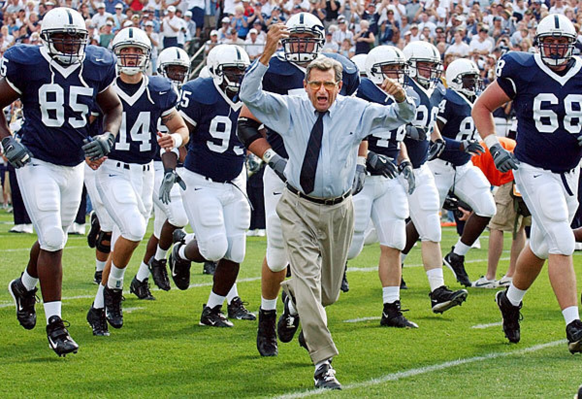 Coach Joe Paterno leads his Penn State team onto the field in 2004 for a game against Akron in State College, Pa.
