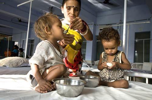 Deep Kumar, 20 months old, left, and 18-month-old Vishal are fed eggs by caretaker Nirmala Devi at the UNICEF-sponsored nutrition rehabilitation center in Saraiya in the impoverished eastern Indian state of Bihar.