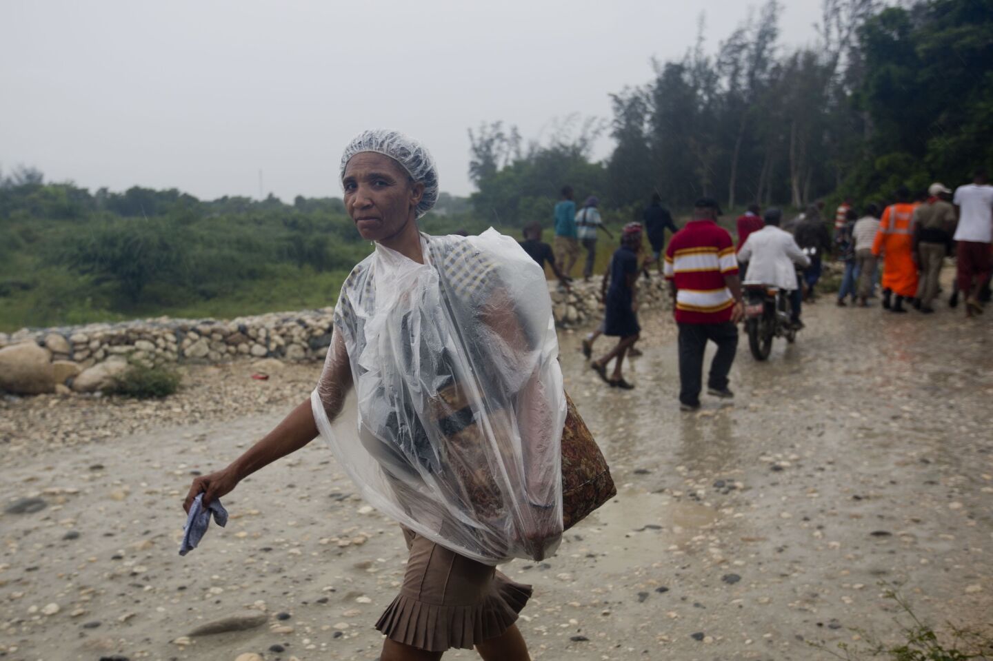 A woman protects herself from the rain with a piece of plastic prior to the arrival of Hurricane Matthew in Tabarre, Haiti.