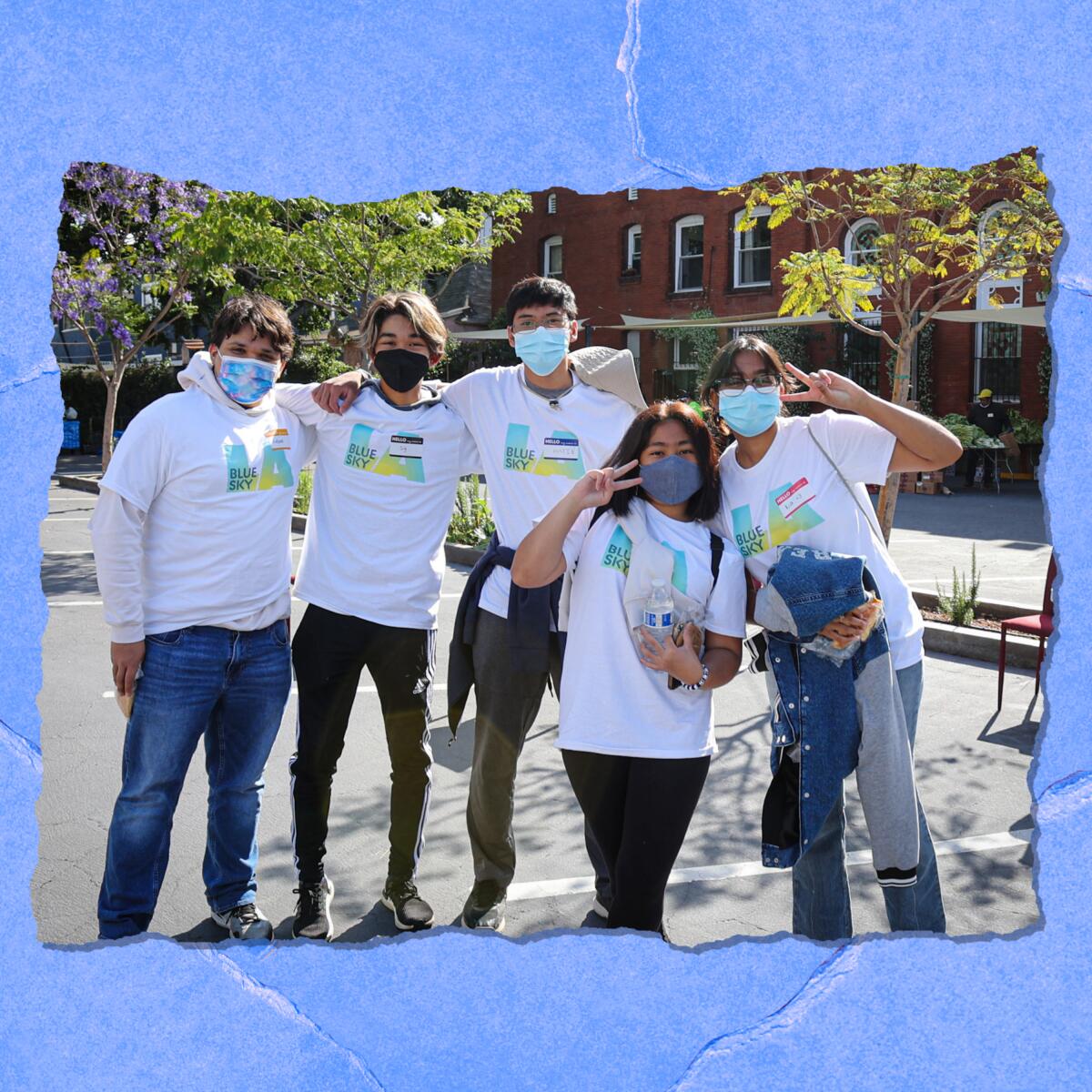 Five young people in matching T-shirts and masks stand casually and smile for the camera.
