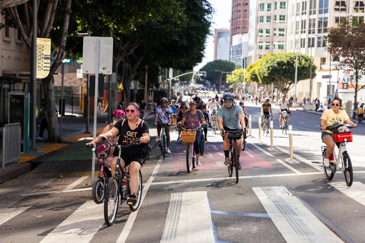 Folks ride bikes on empty DTLA streets