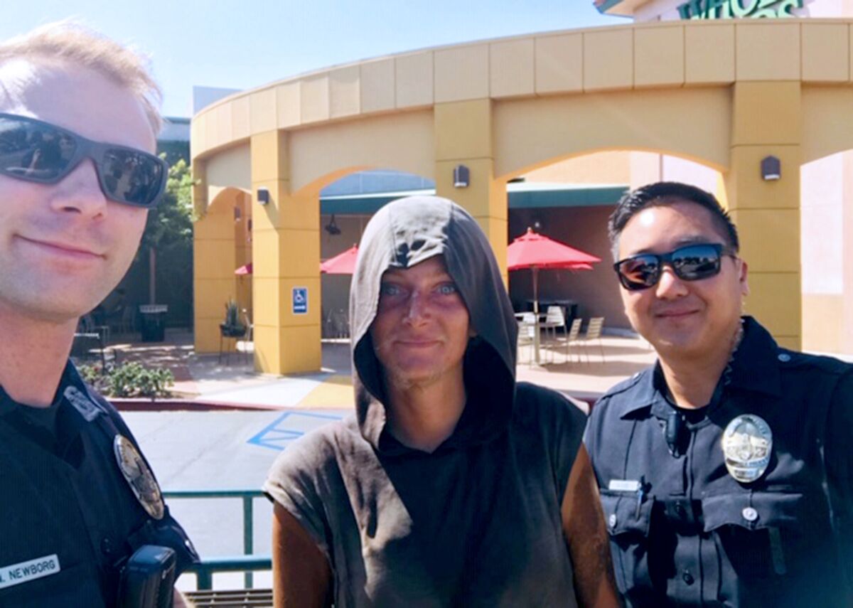 Karol-Ann Roberts with Officers Mark Newborg and Daniel Lee standing in front of the Whole Foods in Glendale near where Roberts had been sleeping on a nearby bus bench after arriving in the city.