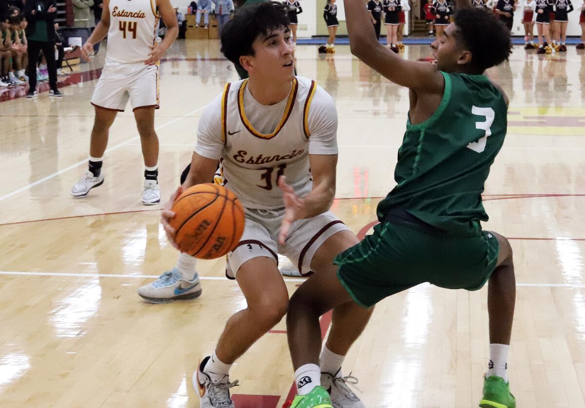 Estancia's Jaedon Hose Shea (31) drives to the basket against Costa Mesa's Marlee Slone (3).