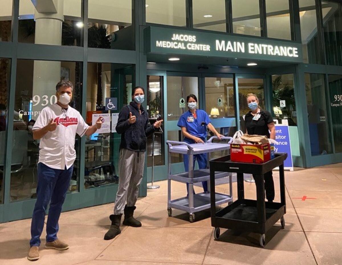 Kathryn Muñoz (second from left) delivers meals to the Jacobs Medical Center at UC San Diego Health.