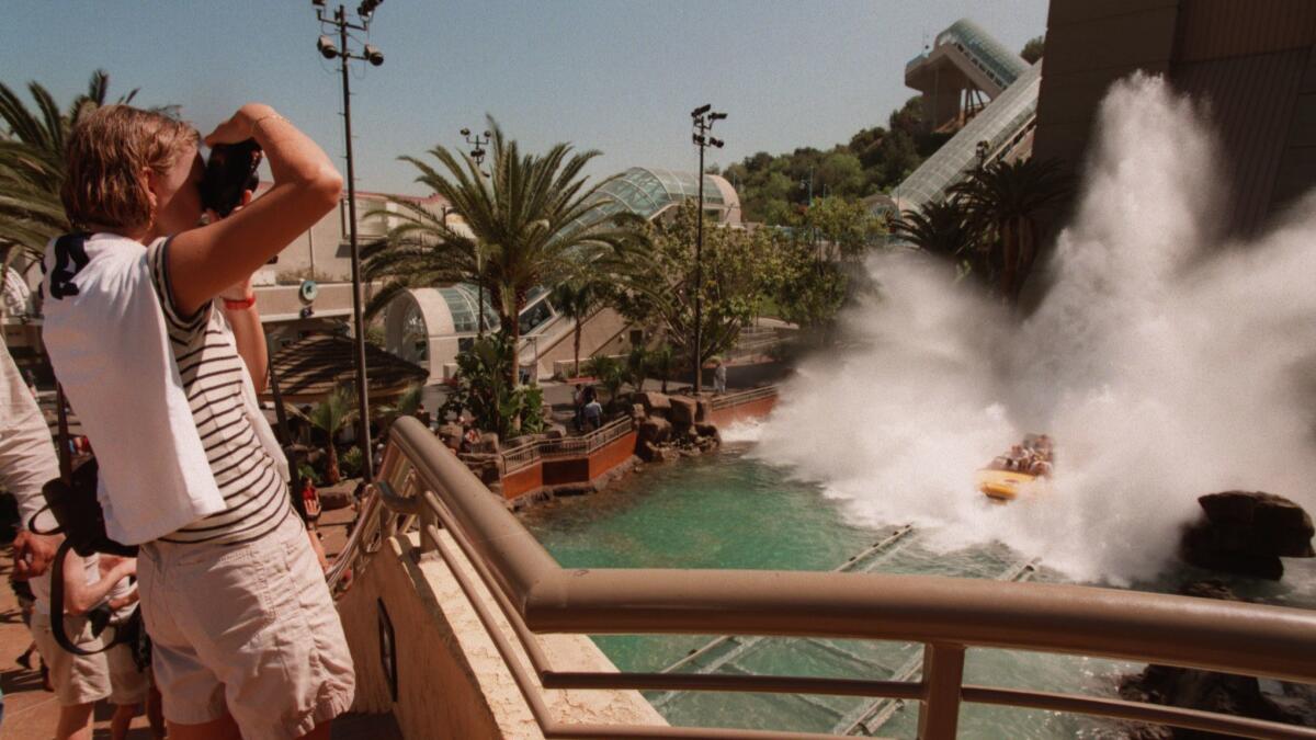 Visitors to Universal Studios Hollywood watch as riders of Jurassic Park -- The Ride splash down the final descent. A study found that the most expensive theme park to visit in the country is Universal Studios Hollywood.