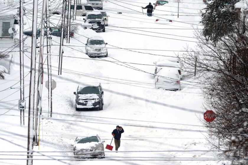 Erie, Pa., residents on East 24th Street dig out on Tuesday, Dec. 26, 2017, after a record two-day snowfall. The National Weather Service office in Cleveland says the storm brought 34 inches on Christmas Day, a new all-time daily snowfall record for Erie. (Greg Wohlford/Erie Times-News via AP)