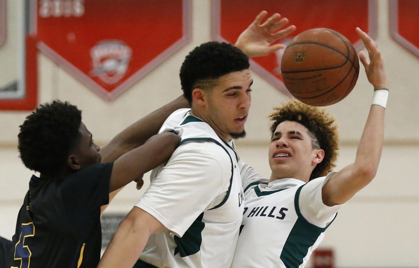 Birmingham's Devonaire Doutrive, left, battles Chino Hills brothers LiAngelo Ball, middle, and LaMelo Ball for control of the ball during the first quarter.