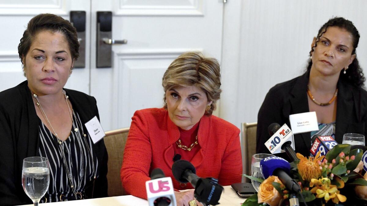 Attorney Gloria Allred, center, addresses reporters at a news conference Sunday in Philadelphia. Her clients Chelan Lasha, left, and Lise-Lotte Lubin have accused Bill Cosby of sexual assault decades ago.