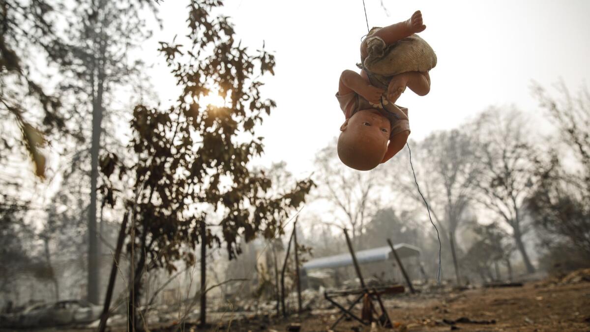 A doll hangs from a string in the backyard of a home that was burned down by the Camp fire in Paradise, Calif., on Nov. 16, 2018.