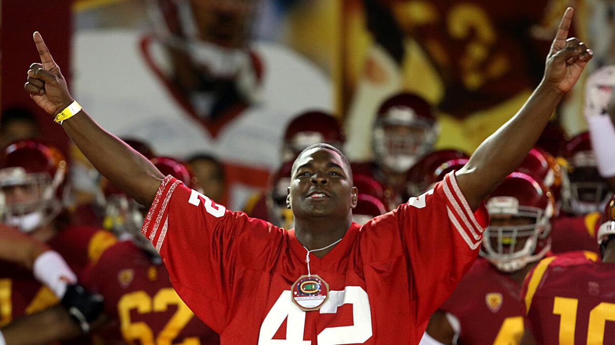 Former USC player Keyshawn Johnson led the Trojans onto the field for a game in 2013. Now he's leading the charge to make Clay Helton the head coach.
