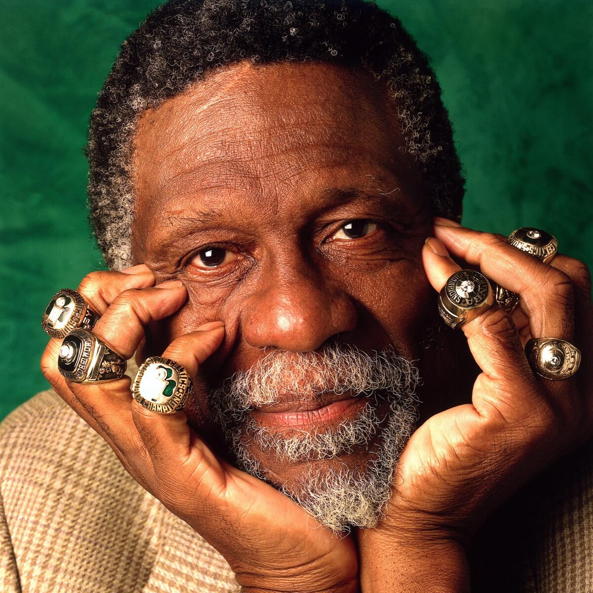 Bill Russell poses for a photo in 1996 with his eleven championship rings.