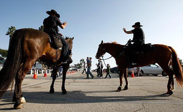Mounted Officers Matt Bennyworth and Ulysses Gasca greet Dodgers fans. See full story