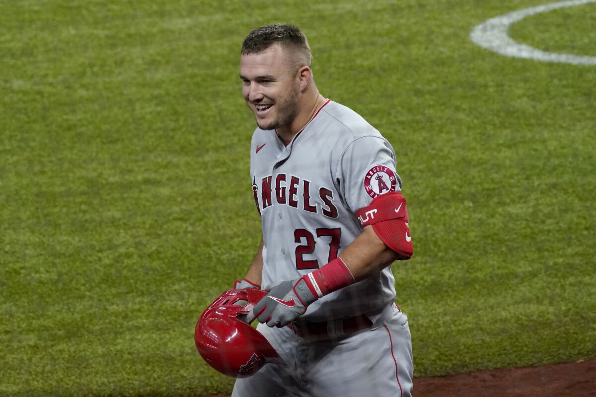 Los Angeles Angels' Mike Trout smiles as he approaches the dugout after hitting a solo home run in the fifth inning of a baseball game against the Texas Rangers in Arlington, Texas, Thursday, Sept. 10, 2020. (AP Photo/Tony Gutierrez)