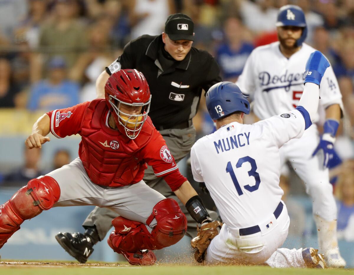 Angels catcher Dustin Garneau puts the tag on Dodges second baseman Max Muncy in the second inning July 23  at Dodger Stadium.