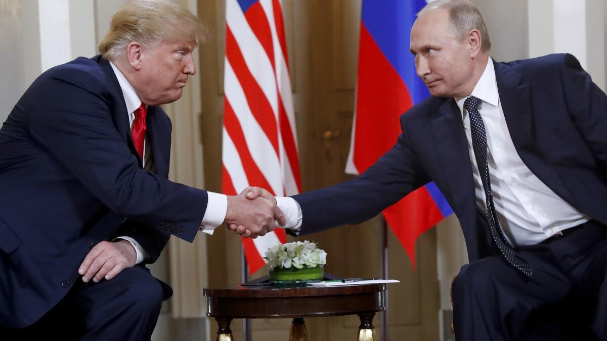 U.S. President Donald Trump, left, and Russian President Vladimir Putin shake hands at the beginning of a meeting at the Presidential Palace in Helsinki, Finland, on July 16.