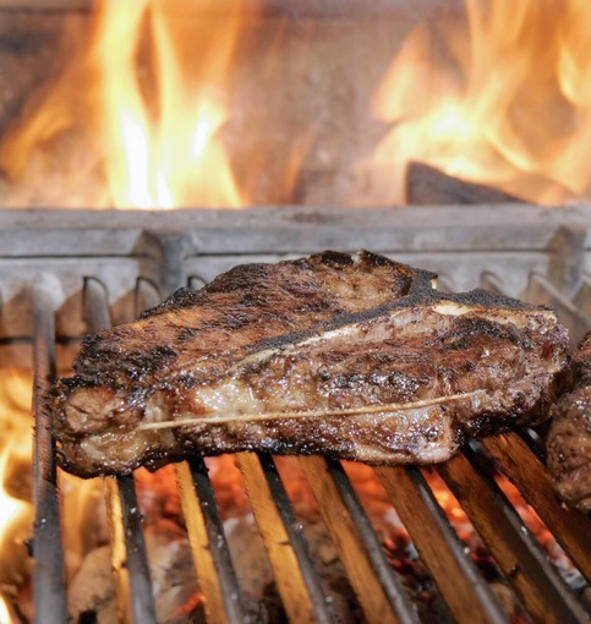 A 32-ounce Porterhouse steak is cooked over a wood fire at Cut in Beverly Hills.