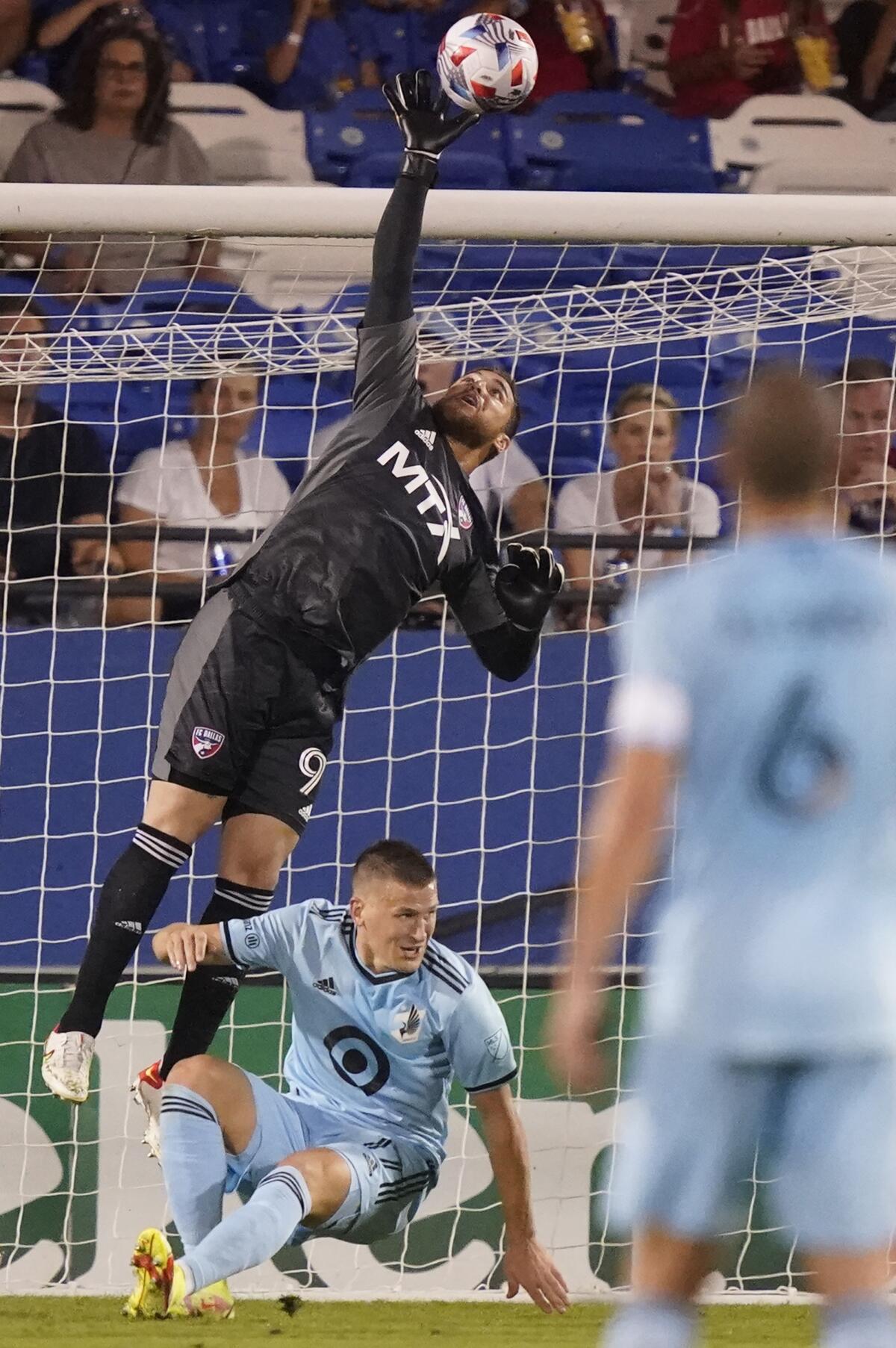 FC Dallas goalkeeper Phelipe Megiolaro (99) makes a save against Minnesota United midfielder Robin Lod (17) during the second half of an MLS soccer match Saturday, Oct. 2, 2021, in Frisco, Texas. (AP Photo/LM Otero)