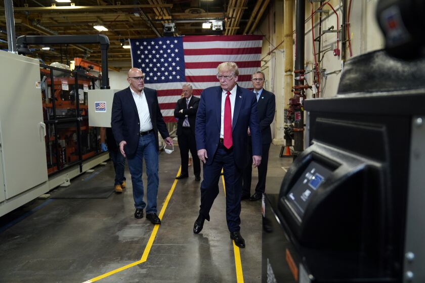 President Donald Trump participates in a tour of a Honeywell International plant that manufactures personal protective equipment, Tuesday, May 5, 2020, in Phoenix, with Tony Stallings, vice president of integrated supply chain at Honeywell International Inc., left and Honeywell CEO Darius Adamczyk. (AP Photo/Evan Vucci)