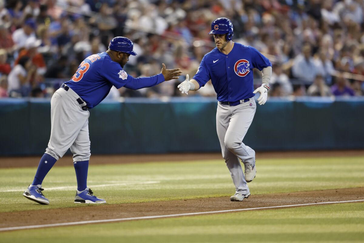 Chicago Cubs' Yan Gomes (7) is greeted by third base coach third base coach Willie Harris as Gomes heads for home on a solo home run during the fourth inning of the team's baseball game against the Arizona Diamondbacks on Saturday, May 14, 2022, in Phoenix. (AP Photo/Chris Coduto)