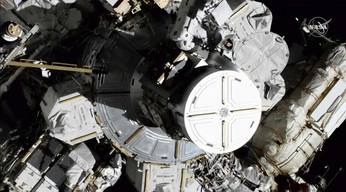 Astronauts Christina Koch and Jessica Meir (upper right) exit the International Space Station on Friday. This is the first time in a half-century of spacewalking that a woman floated out without a male crew mate.
