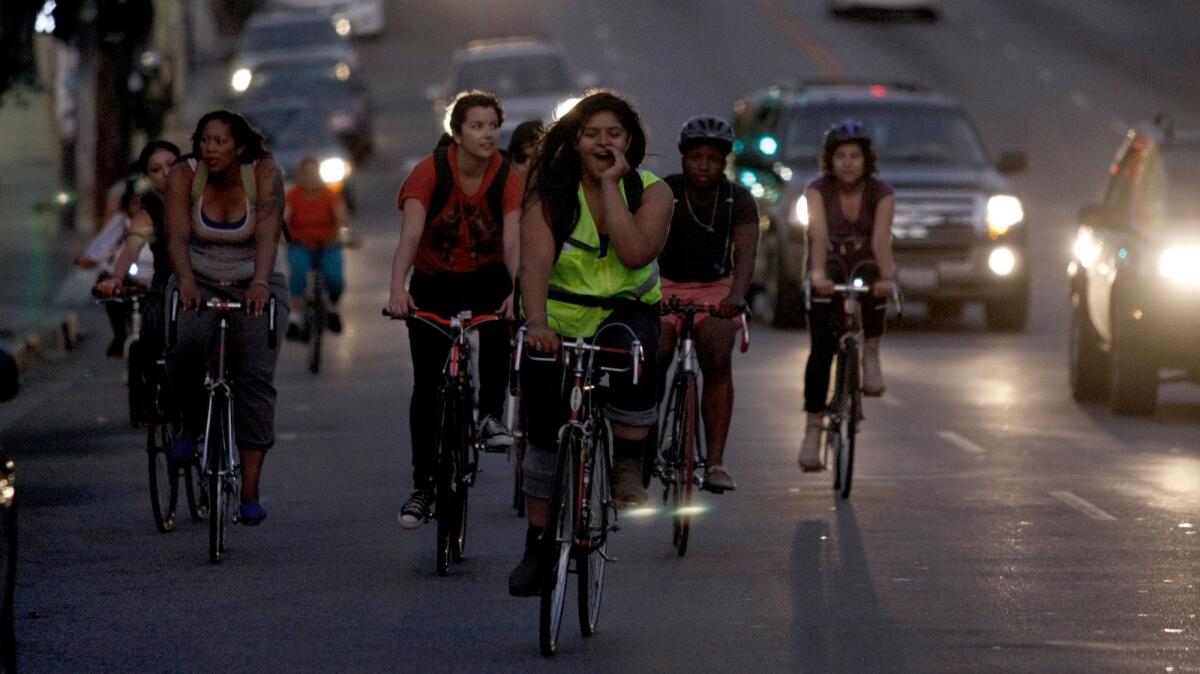 Evelyn Martinez (front/green vest), shouts instructions as she, along with other female riders and some members of the Ovarian Psycos, ride through the Boyle Heights area of Los Angeles.