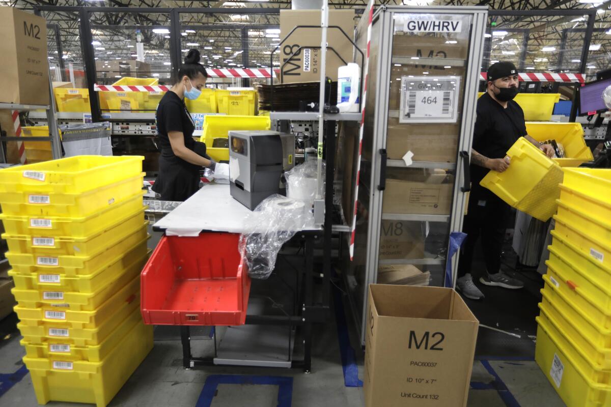 Workers package orders at the Amazon Fulfillment Center in Moreno Valley in 2021.