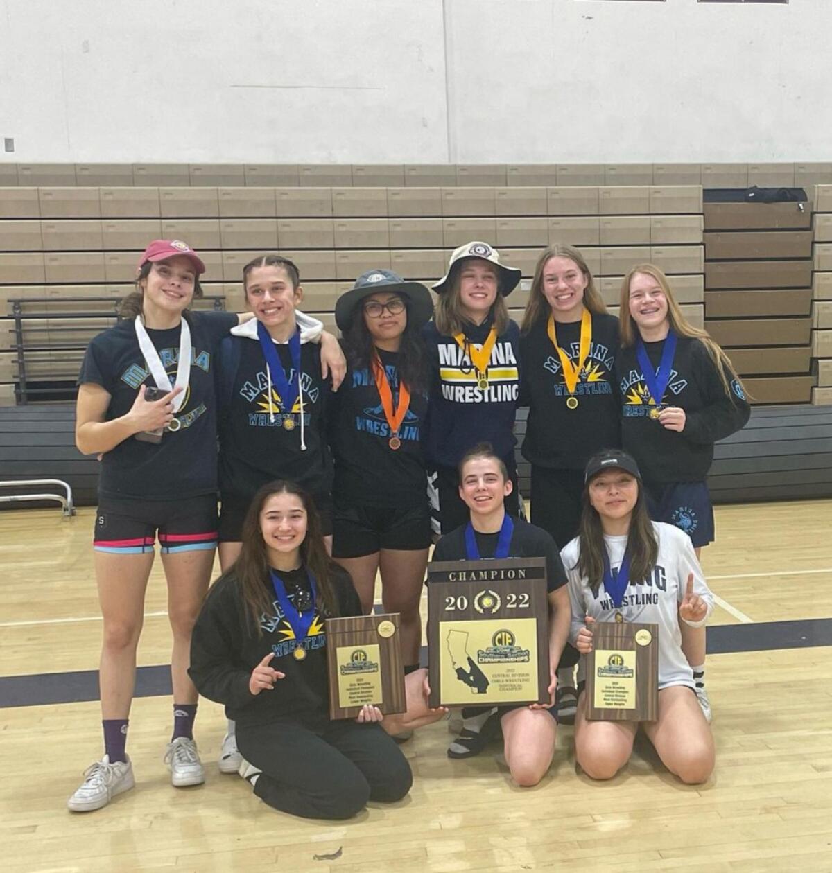 The Marina High School girls' wrestling team poses with the CIF Southern Section Central Division championship plaque.