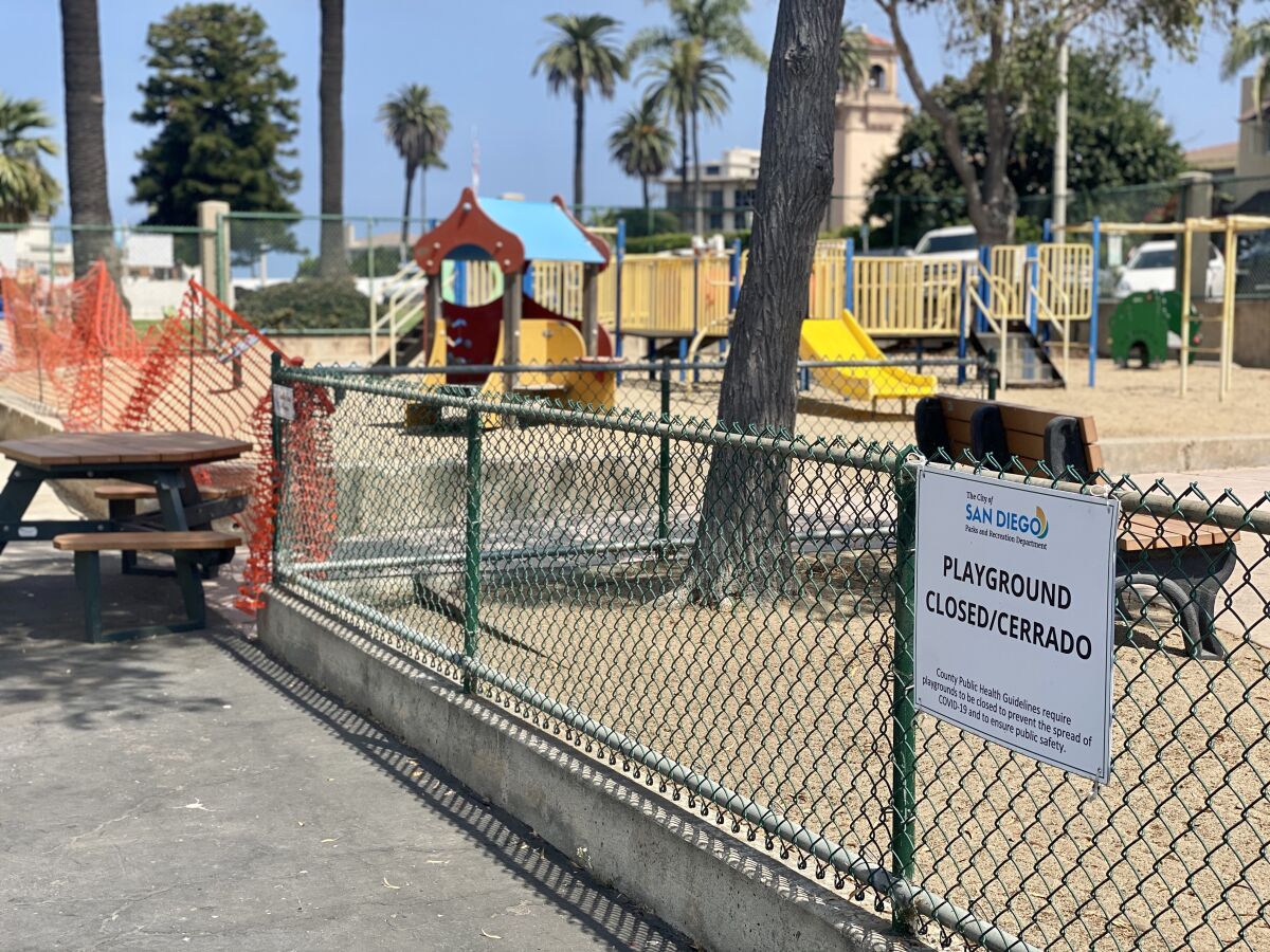 The La Jolla Recreation Center playgrounds are closed off by plastic orange fencing, with signs prohibiting their use.