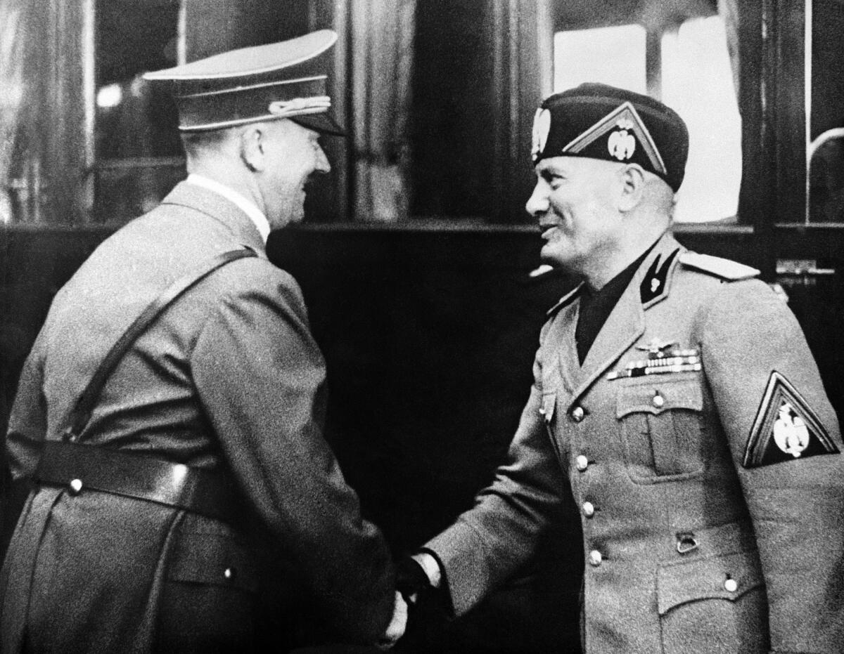 Adolf Hitler, left, greets Italian dictator Benito Mussolini