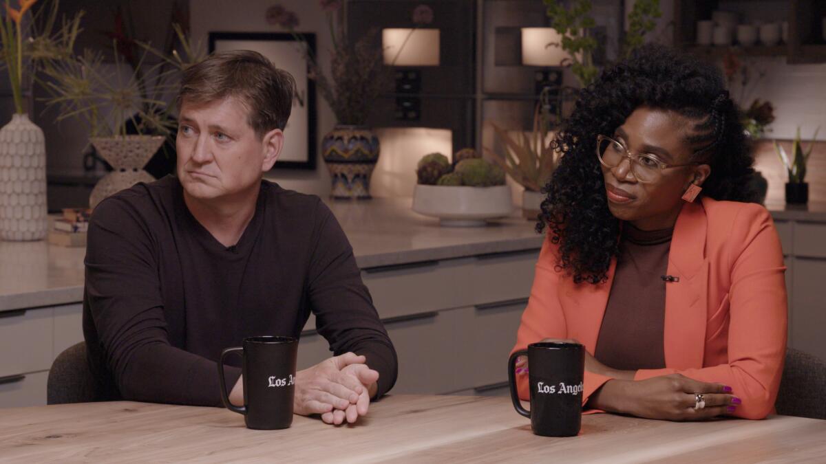 A man and a woman sit at a table during discussion