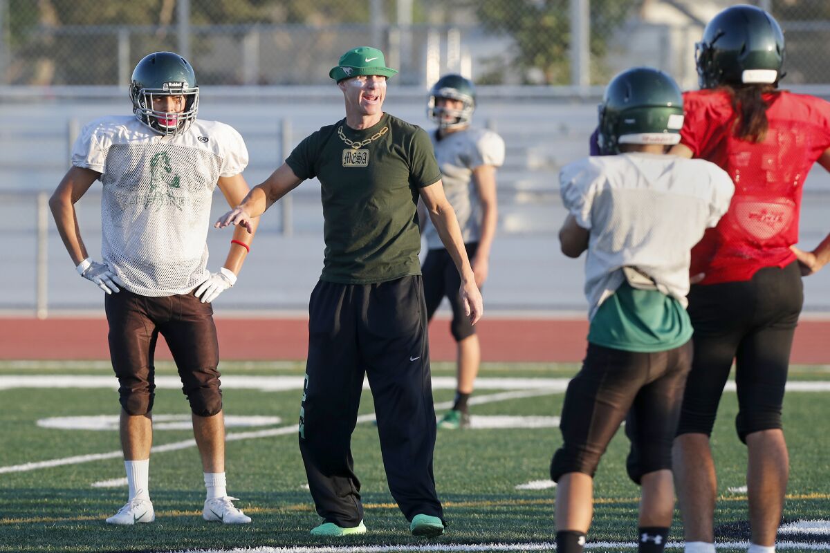 Coach Jimmy Nolan, center, gives instructions during football practice at Costa Mesa High School on Aug. 26, 2019.