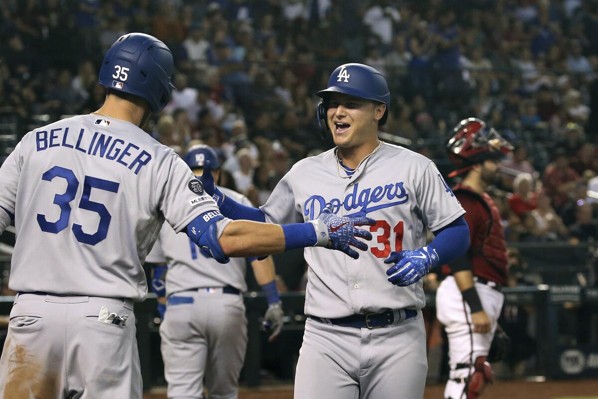 Joc Pederson is congratulated by Dodgers teammate Cody Bellinger after hitting a tiebreaking home run against the Diamondbacks in the 11th inning Sunday.