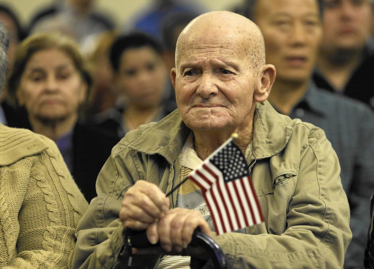 An 85-year-old immigrant from Cuba holds an American flag before being sworn in during a naturalization ceremony held Jan. 22 in Hialeah, Fla.