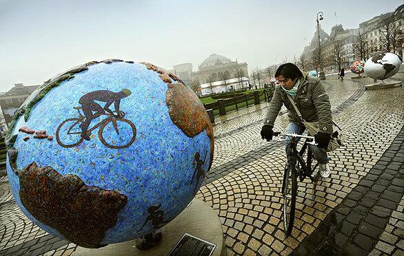 A cyclist stops to look at "Cool Globes," an exhibition in the Kongens Nytorv area of Copenhagen about combating global warming and climate change. The Danish capital is hosting a two-week conference to discuss emissions targets and financial measures to mitigate climate change. The landmark conference opened today, with negotiators from 192 countries aiming toward a deal to ward off the potentially catastrophic effects of climate change.