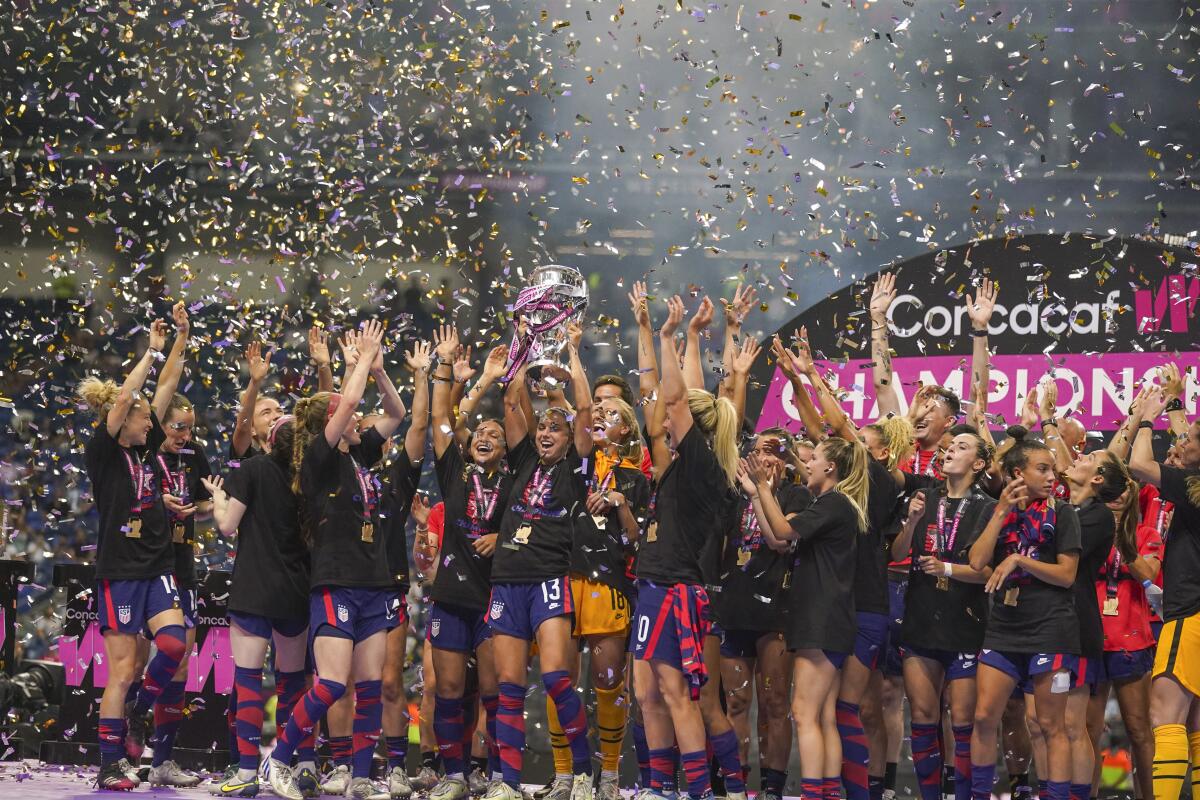 United States' players hold the trophy as they celebrate winning the CONCACAF Women's Championship final against Canada.