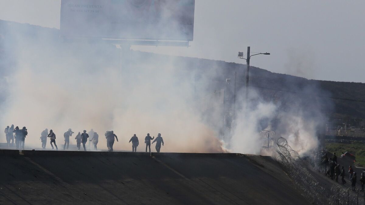 Migrants run from tear gas fired by U.S. Border Patrol on the U.S.-Mexico border in Tijuana.