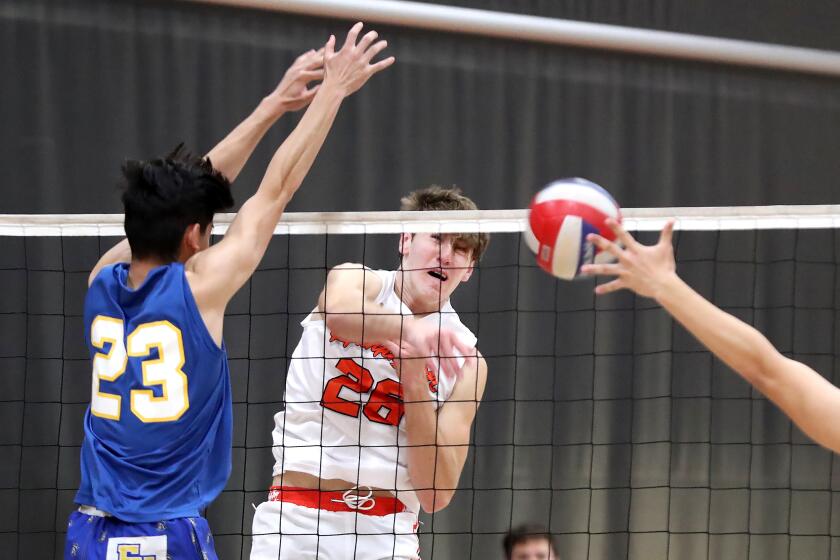 Jake Pazanti (26) of Huntington Beach puts a kill away past the block of Byron Nguyen.