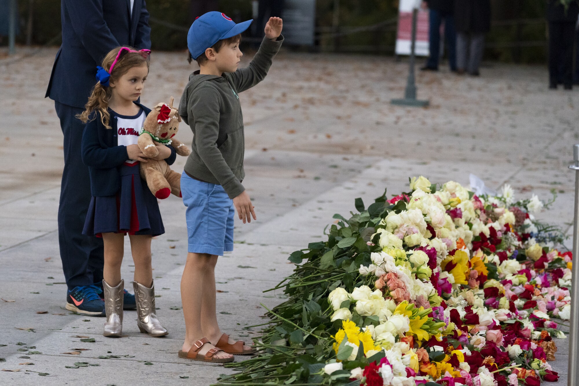 A girl watches her brother salute after they placed flowers at the Tomb of the Unknowns
