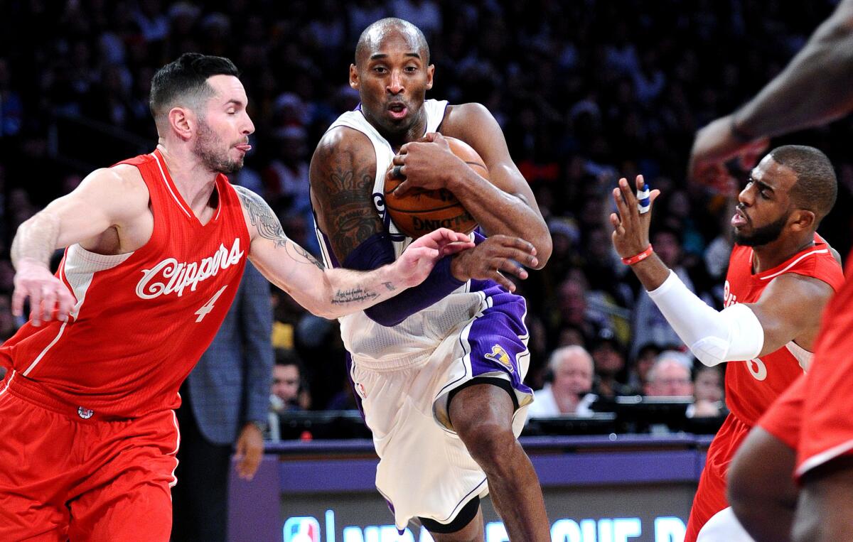 Lakers guard Kobe Bryant tries to split the defense of Clippers guards J.J. Redick, left, and Chris Paul during a drive in the second quarter of a game on Dec. 25.